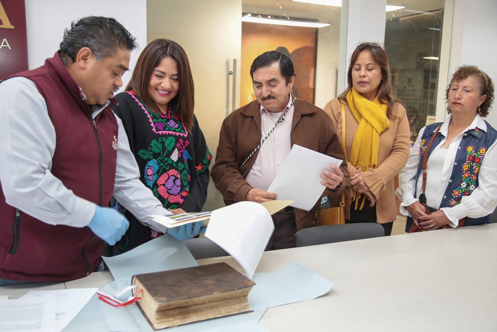 La Mtra. Neyda Naranjo Baltazar realiza la devolución de un libro del siglo XVI que fue estabilizado, a sus custodios del municipio de San Agustín Tlaxiaca, Hidalgo, México.
